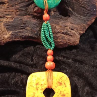 PAPRIKA Pendentif coloré en pierre avec des perles vertes et oranges, suspendu à un cordon.
