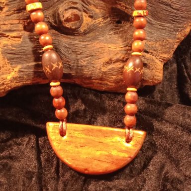 TERRE MERE Collier en bois avec pendentif semi-circulaire et perles en bois.