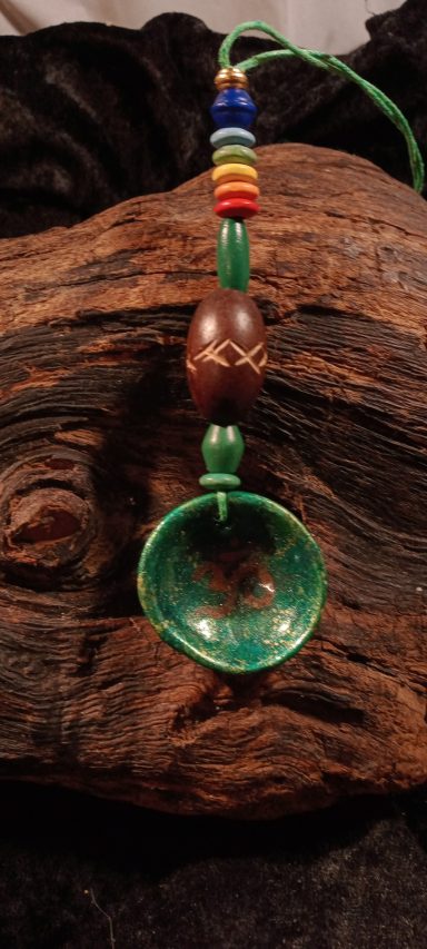 AUM Pendentif avec une cuillère verte et des perles colorées sur un cordon.